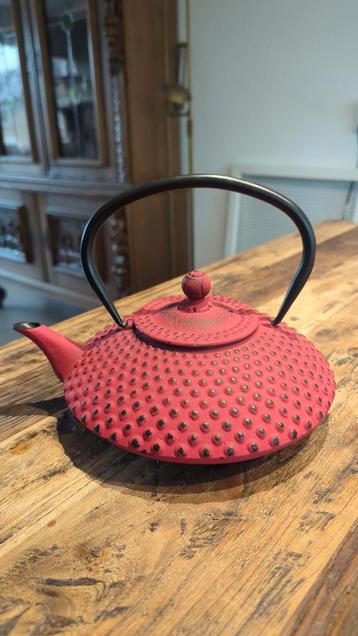 Rode gietijzeren theepot beschikbaar voor biedingen