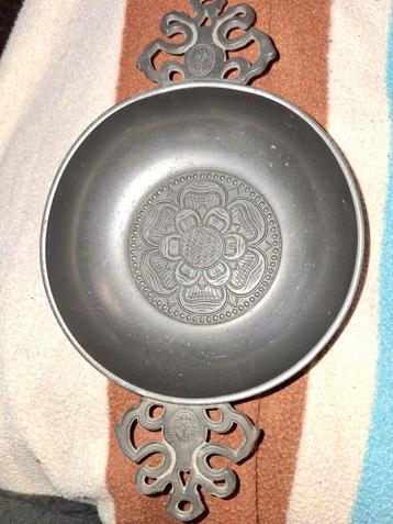 Tinnen schaal met decoratieve handvatten beschikbaar voor biedingen