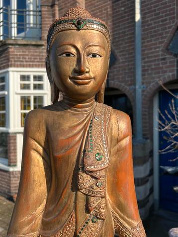 Grote vergulde staande Boeddha op zwart houten basement beschikbaar voor biedingen