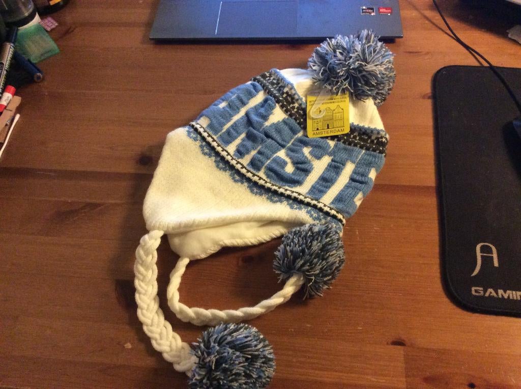 Flapmuts Amsterdam. fleece gevoerd. met pompons. Nieuw, Kleding | Dames, Mutsen, Sjaals en Handschoenen, Ophalen of Verzenden