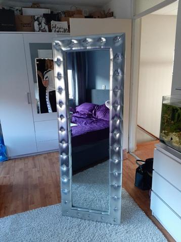 Moderne spiegel met zilverkleurige rand beschikbaar voor biedingen