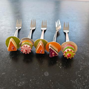 Taartvorkjes met taart en gebakjes erop vorkje beschikbaar voor biedingen