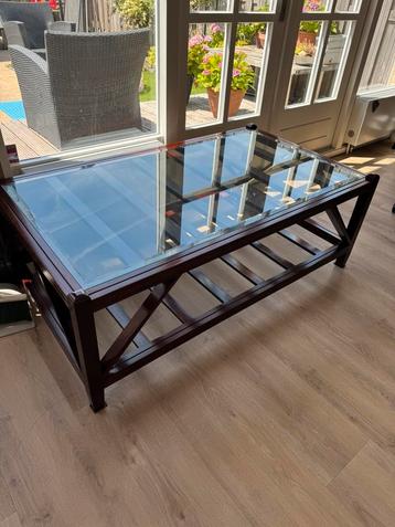 Houten tafel met glazen blad beschikbaar voor biedingen