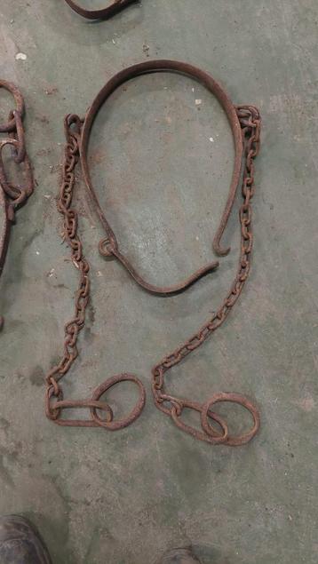 Antieke ijzeren koeienboeien met ketting beschikbaar voor biedingen