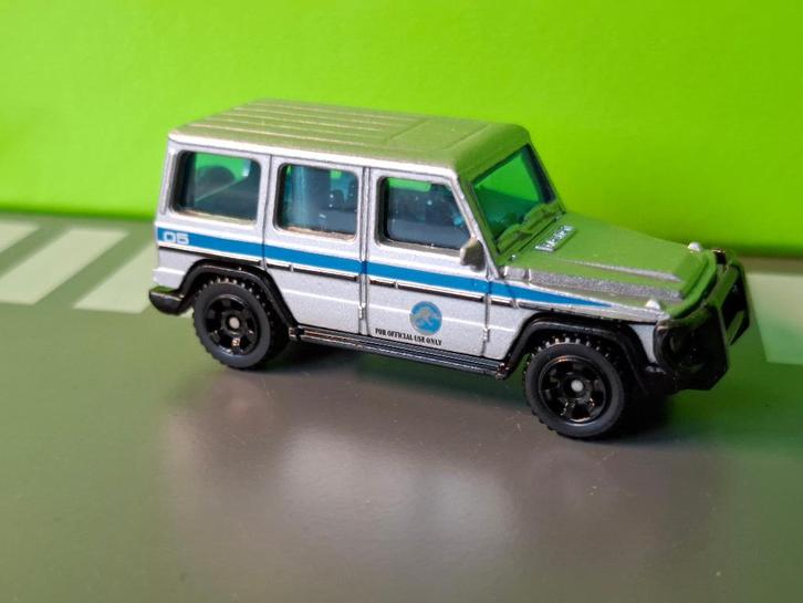 Matchbox - 2014 Mercedes G550 Jurassic Park [grijs] 1/60, Hobby en Vrije tijd, Modelauto's | Overige schalen, Zo goed als nieuw