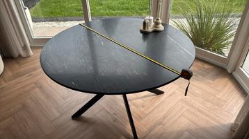 Zwarte marmeren eettafel met rustig gemarmerd blad.