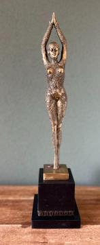Een bronzen gepolijst beeld van een danseres.