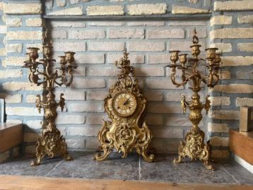 Zeer mooie antieke schouwklok met 2 kandelaars beschikbaar voor biedingen