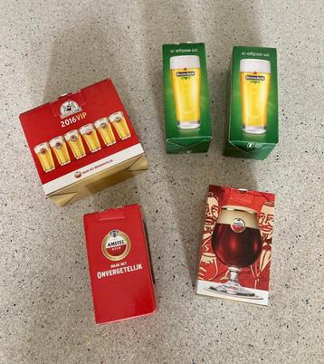 Set Heineken / Amstel glazen met schuimafstrijkers beschikbaar voor biedingen