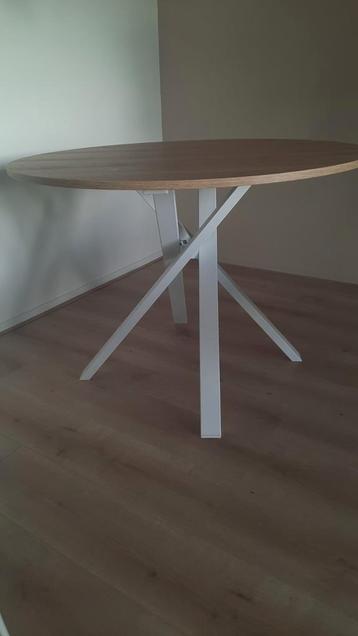 Ronde houten eettafel met wit onderstel beschikbaar voor biedingen