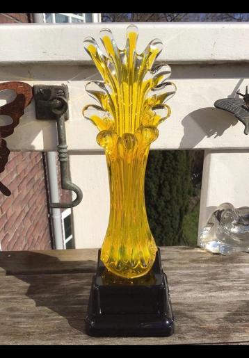 Gele glazen vaas met 12 punten op een zwarte voet. Geel glas beschikbaar voor biedingen