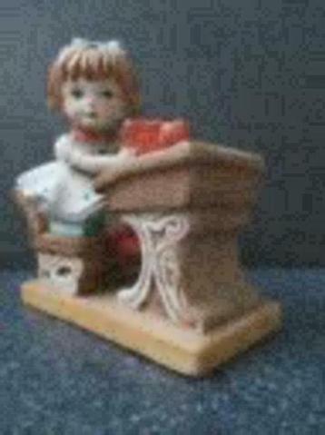 Schoolmeisje beeldje van meisje aan haar lessenaar. beschikbaar voor biedingen