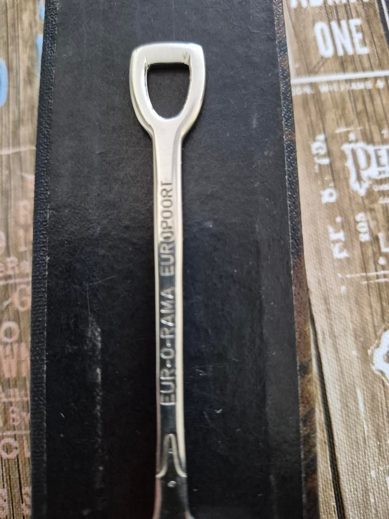 Zilverkleurige lepel met flesopener en reliëf, Antiek en Kunst, Antiek | Bestek, Ophalen of Verzenden