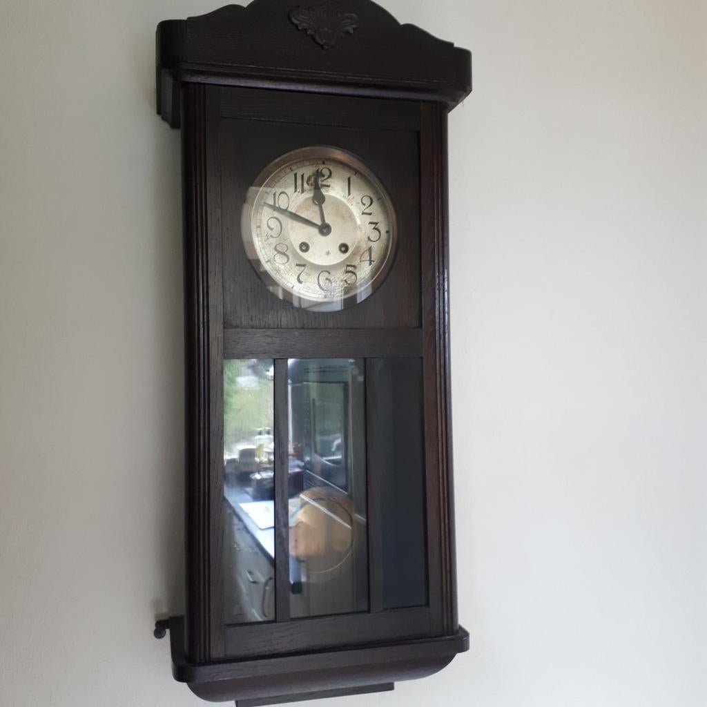 Antieke wandklok met slinger en opwind mechanisme, Ophalen