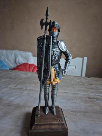 Ridderfiguur in harnas op een houten blok.  beschikbaar voor biedingen