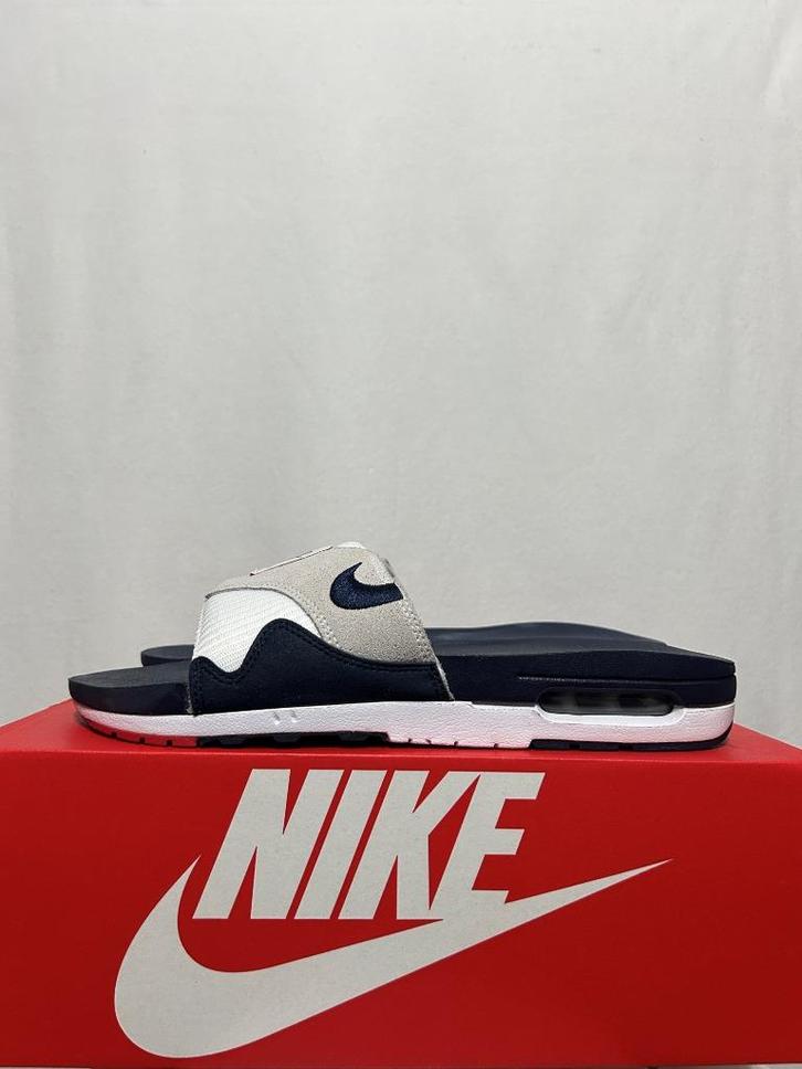 NIEUW! Maat 45 - Nike Air Max 1 Slide Obsidian University, Kleding | Heren, Schoenen, Nieuw, Slippers, Overige kleuren, Verzenden