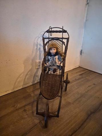 Antieke poppenwagen met porseleinen pop beschikbaar voor biedingen