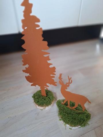 Roestige hert met dennenboom beschikbaar voor biedingen