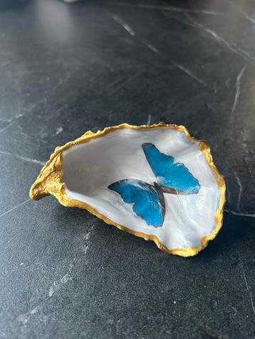 Oester met blauwe vlinder en gouden rand beschikbaar voor biedingen