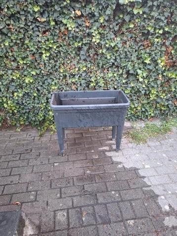 Grijze plantenbak met poten. beschikbaar voor biedingen