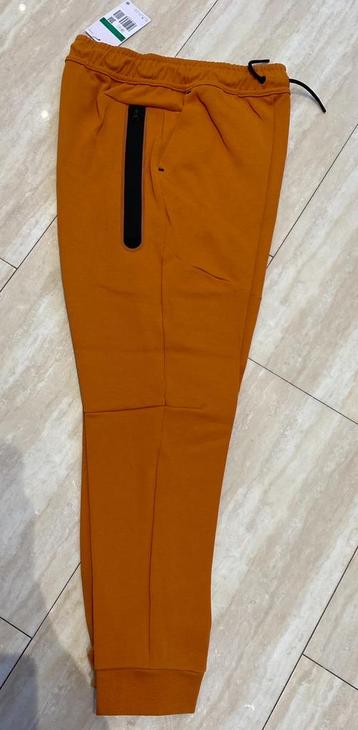Nike tech fleece broek, kleur oranje met zwart €39,95.