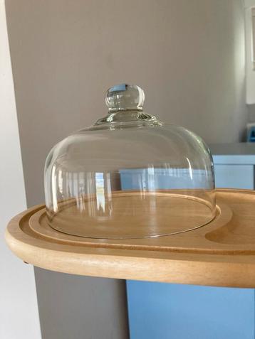 Glazen stolp met houten serveerplank beschikbaar voor biedingen