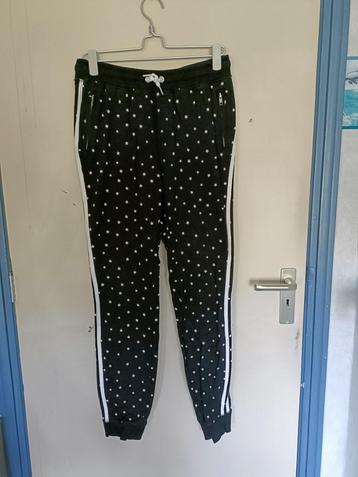 Een zwarte jogging broek met witte sterretjes er op. beschikbaar voor biedingen