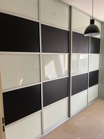 Schuifdeurkast met zwart en wit glaspanelen
