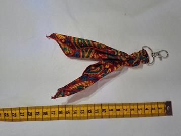 Sleutelhanger van rood/ oranje/ blauw geknoopt doekje. beschikbaar voor biedingen