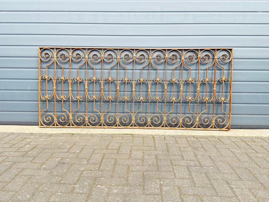 Antiek smeedijzeren hekwerk met sierlijke krullen en patina, Ophalen of Verzenden, Gebruikt, IJzer, Sierhekwerk