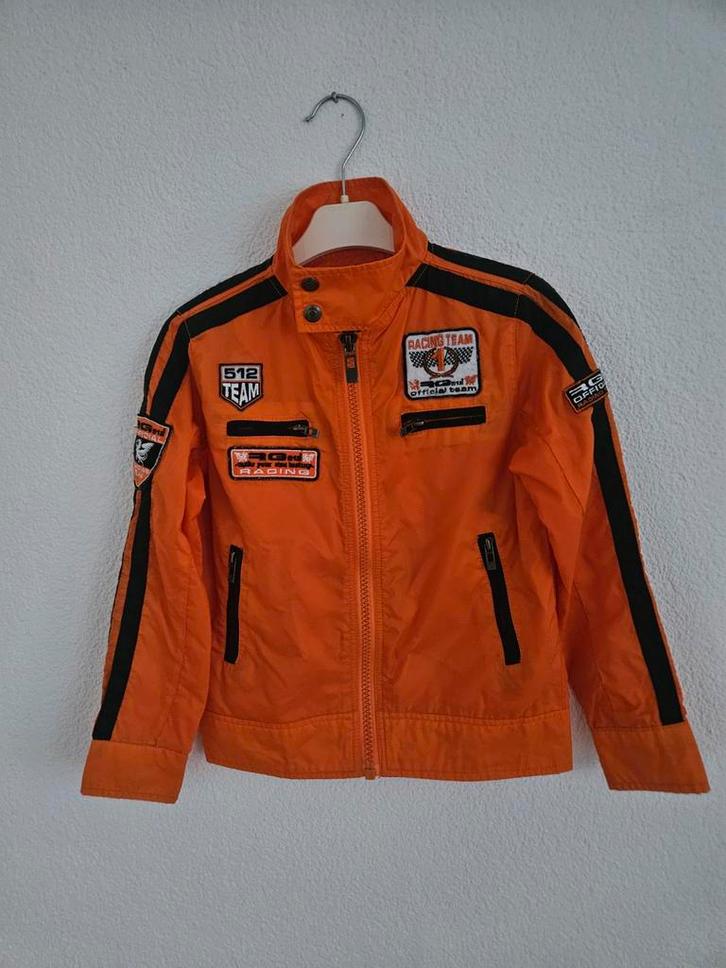 Oranje Jas met Racing Team Emblemen maat 128 zeer goede staa, Kinderen en Baby's, Kinderkleding | Overige, Zo goed als nieuw, Jongen