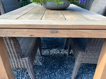 Teaktafel met vier wickerstoelen met kussens beschikbaar voor biedingen