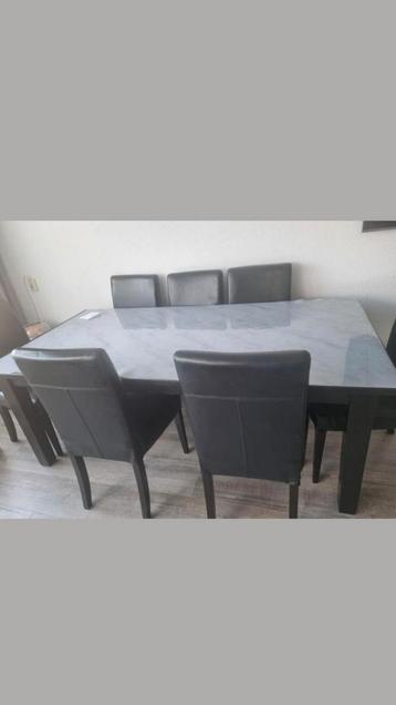Goed onderhouden eettafel met 8 stevige leren stoelen beschikbaar voor biedingen