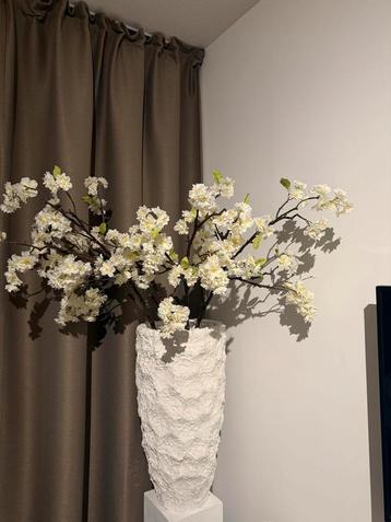 Witte pot met bloesemtakken beschikbaar voor biedingen