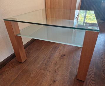 Glazen salontafel met houten poten beschikbaar voor biedingen