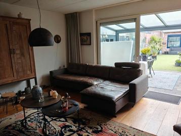 Grote leren bank met chaise longue beschikbaar voor biedingen