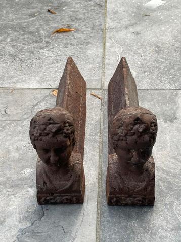 Antieke haardbokken met gezichtjes beschikbaar voor biedingen