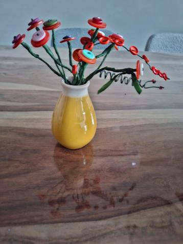 Vaasje met bloemetjes van knopen beschikbaar voor biedingen