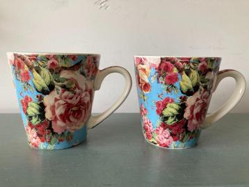 Twee koffiebekers met rozen beschikbaar voor biedingen