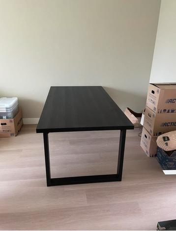 zwarte eettafel met stalen poten beschikbaar voor biedingen