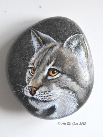Portret van een stoere lynx geschilderd op riviersteen beschikbaar voor biedingen