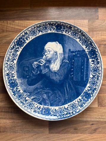 Delftsblauw wandbord 33 cm met een scène van een naaister. beschikbaar voor biedingen