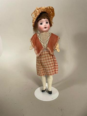 Antiek popje met porseleinen hoofdje in originele kleding beschikbaar voor biedingen