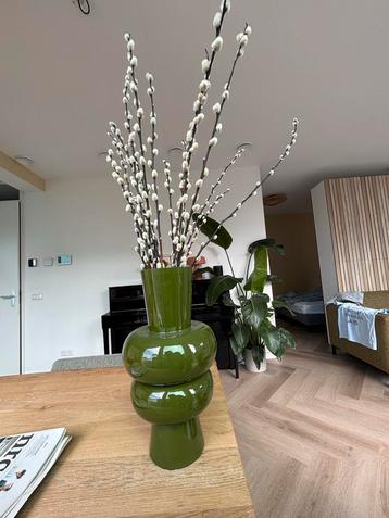 Groene vaas met bloemen beschikbaar voor biedingen