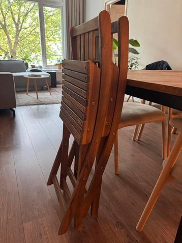 Twee uitklapbare houten stoelen beschikbaar voor biedingen