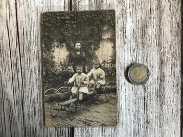 Oude foto twee kinderen op een skelter met handbediening 