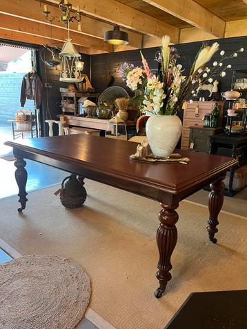Mahoniehouten eettafel met koperen wieltjes beschikbaar voor biedingen