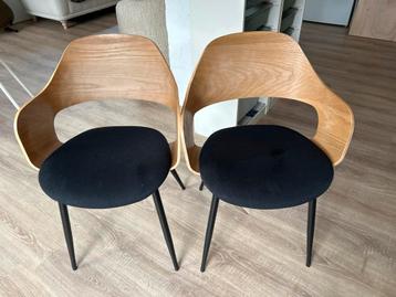 Twee Houten stoelen met zwarte poten beschikbaar voor biedingen