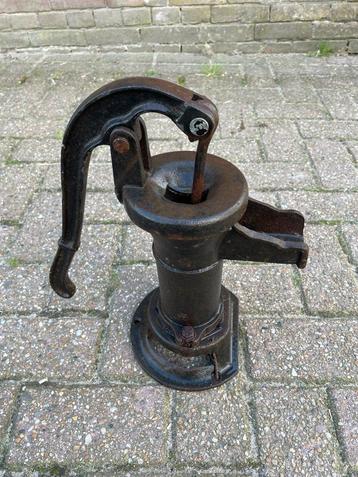 Antieke handwaterpomp met wateraansluiting beschikbaar voor biedingen