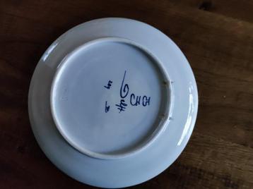 9 keramiek borden in houten rek beschikbaar voor biedingen